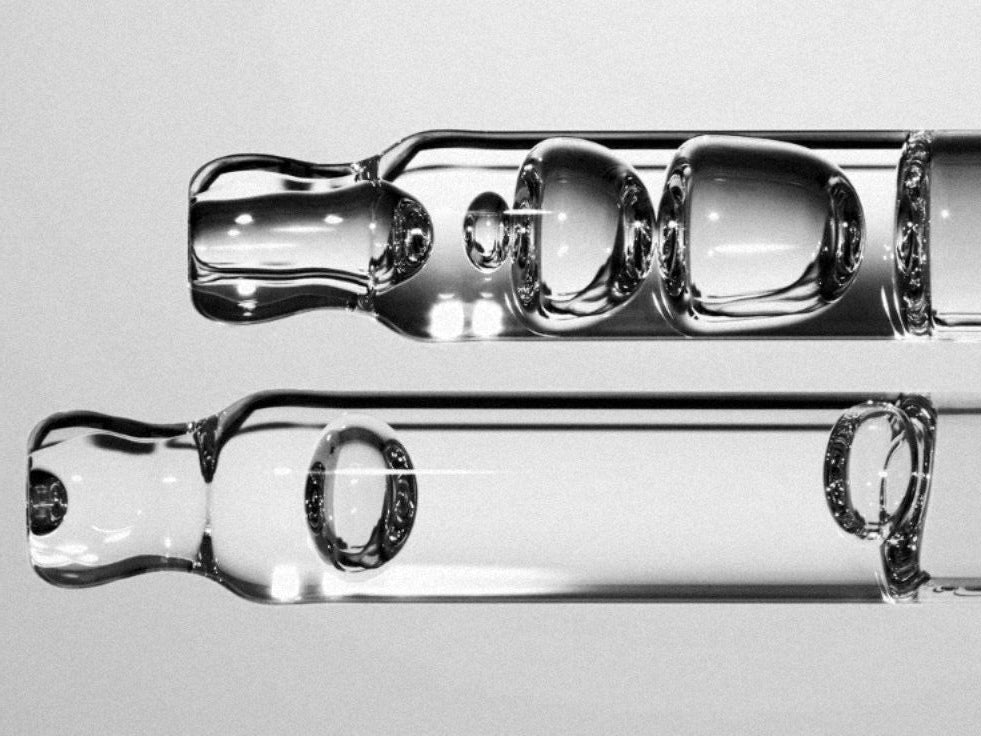 Two glass tubes with water droplets on a gray background