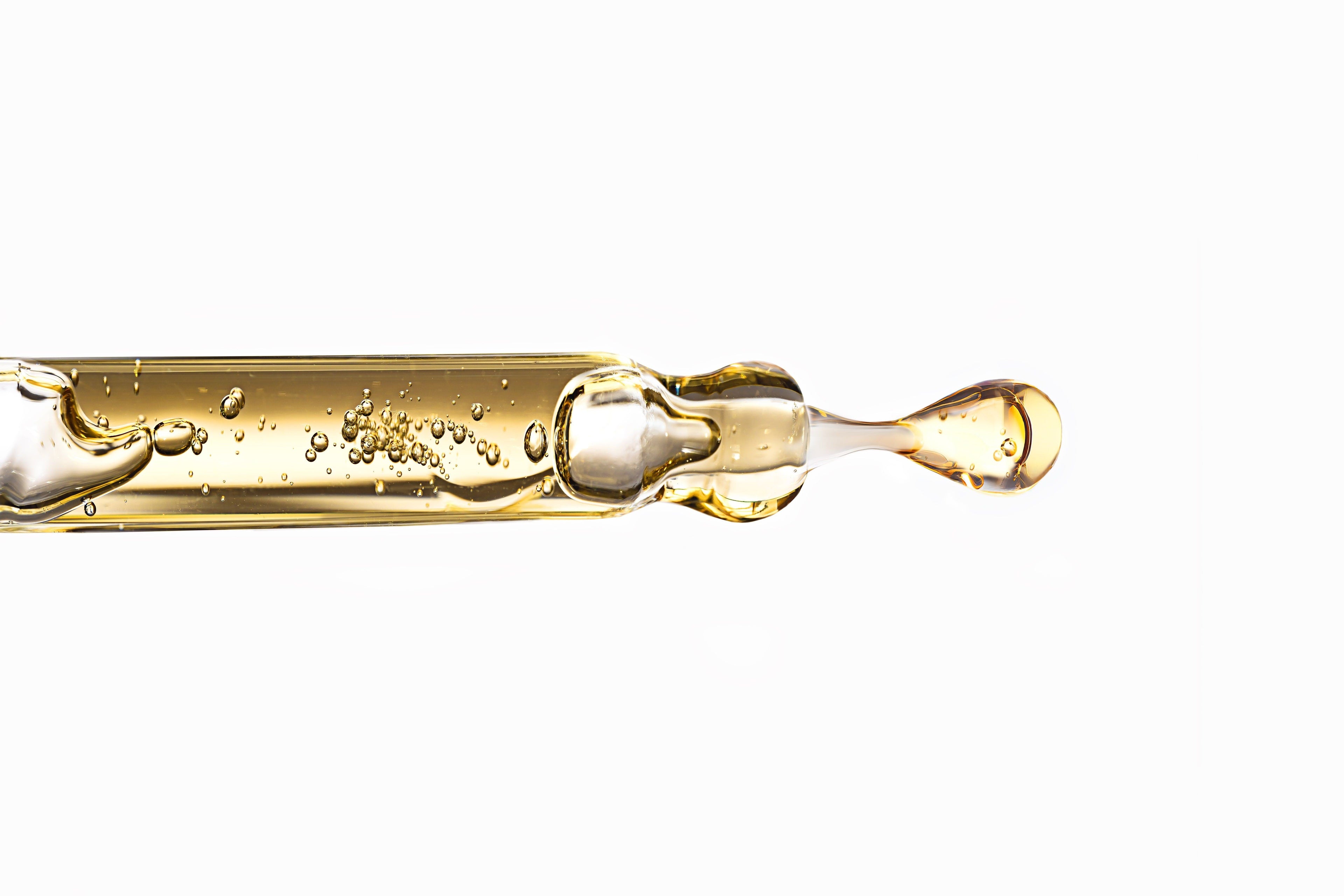 Gold dropper with liquid on a white background