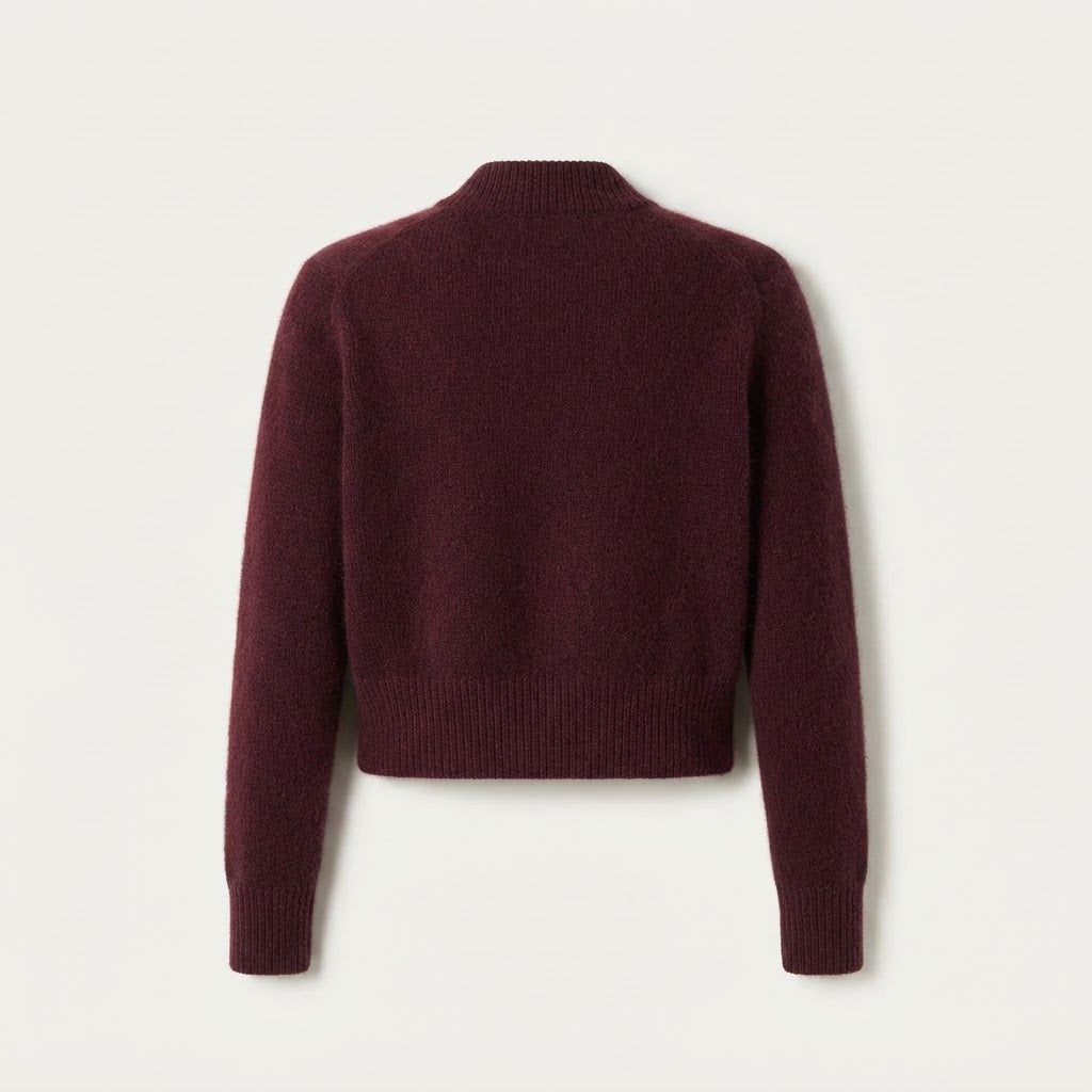 A cropped, long-sleeve knit sweater in a deep burgundy or maroon color, shown from the back against a light off-white background.