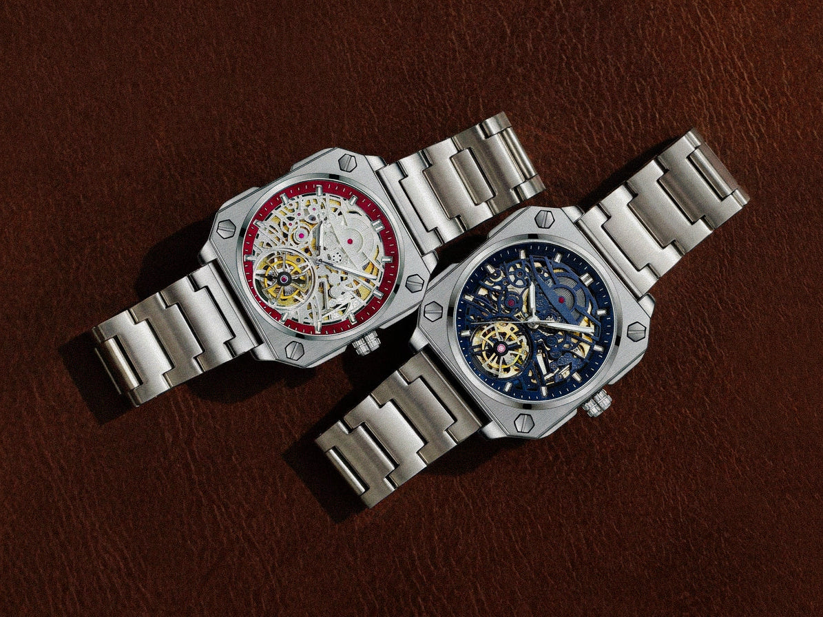 Two silver watches with intricate designs on a brown leather background