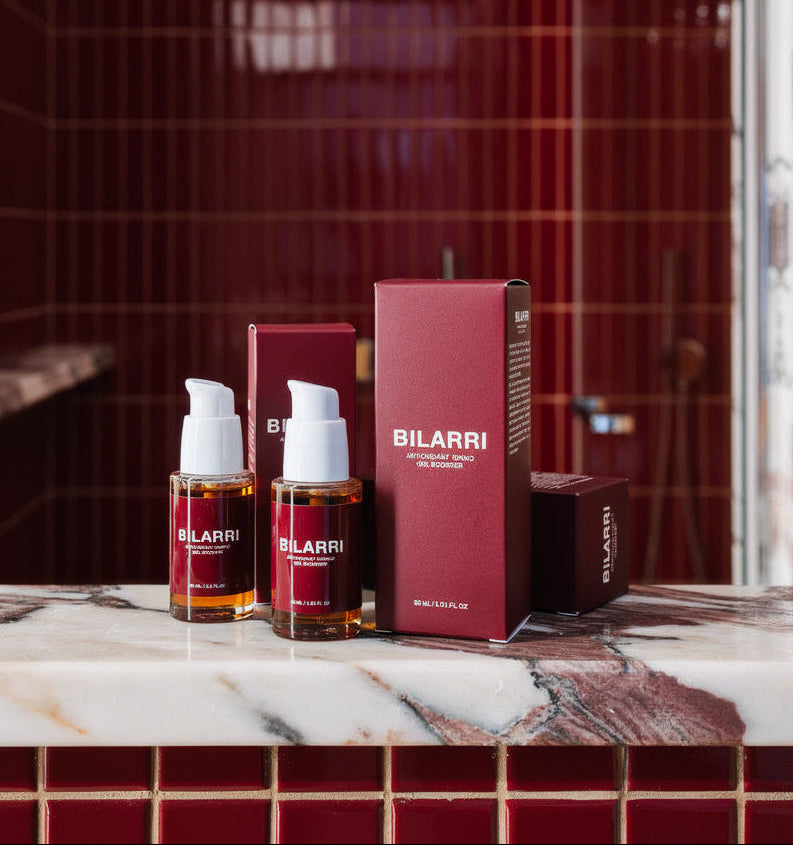 Bilarri skincare products on a marble counter with a red tiled wall in the background